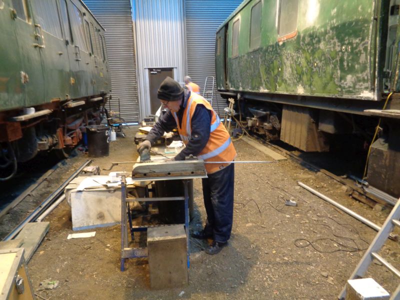 Ron Kirby at work on the guard's compartment door. Meanwhile Thumper 1132 power car on the right awaits a lick of undercoat.brPhotographer David BellbrDate taken 28022019
